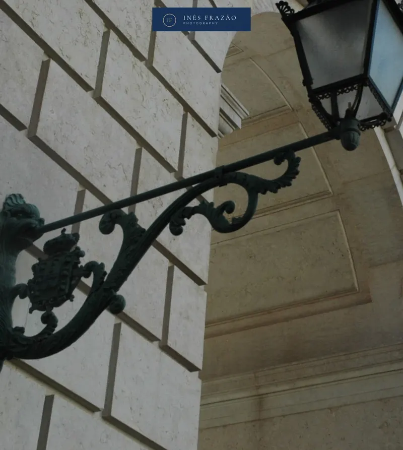 Candeeiro minimalista numa parede moderna, detalhe arquitetónico captado por Inês Frazão.