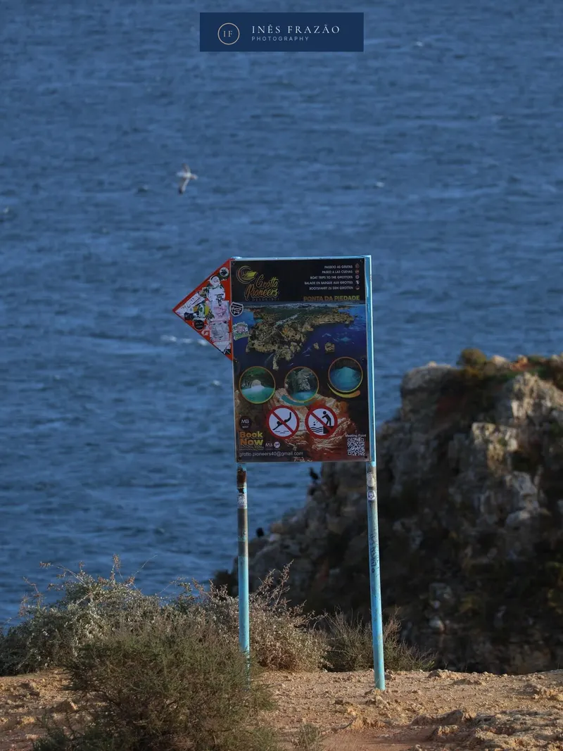 Placa gasta no topo de uma falésia sobre o mar azul profundo, fotografia de paisagem costeira por Inês Frazão.
