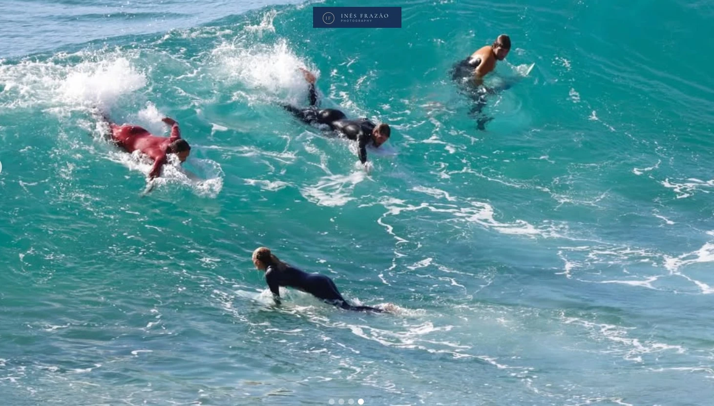 Grupo de surfistas a remar na direção das ondas, numa cena dinâmica que transmite movimento e espírito de equipa. Fotografia de ação por Inês Frazão.