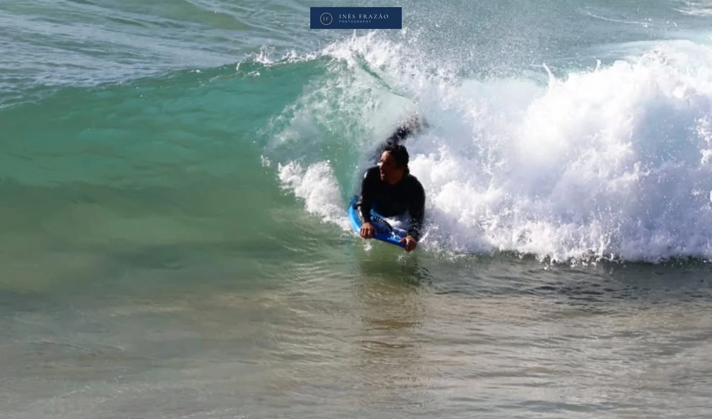 Bodyboarder a entrar na onda com energia e foco, captado no momento exato em que a água se molda ao movimento. Fotografia de desporto aquático por Inês Frazão.