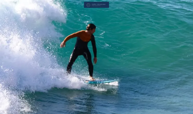 Surfista a realizar uma manobra suave na parede da onda, num movimento elegante captado no ponto alto da ação. Fotografia de surf por Inês Frazão.